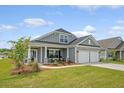 Inviting curb appeal with gray siding, stone accents, and a cozy front porch with rocking chairs at 317 Fiddleback Dr, Summerville, SC 29486