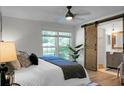 Bright main bedroom with a barn door to the en-suite bathroom and large windows at 32 Heathwood Dr, Charleston, SC 29407