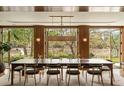 Elegant dining room with long wood table and chairs offering scenic outdoor views through large windows at 333 W Confederate Cir, Charleston, SC 29407