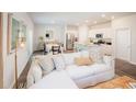 Open concept living room with white sofa, dining area, and kitchen with stainless steel appliances at 339 Pine Crest View Dr, Summerville, SC 29486