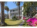 Charming two-story home with a column-lined balcony and lush garden featuring vibrant pink azaleas at 34 Smith St, Charleston, SC 29401