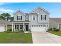 Charming two-story home with gray siding, black shutters, and a well-manicured lawn on a sunny day at 3438 Great Egret Dr, Johns Island, SC 29455