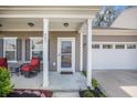 Cozy covered porch with red wicker chairs, complementing the home's facade and inviting entrance at 403 Fox Sparrow Ct, Summerville, SC 29486