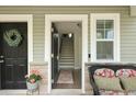 Inviting entryway with an open door, stairs leading up, and lovely decorated with a wreath and seating at 4143 Rigsby Ln, Charleston, SC 29414