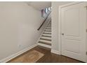 Staircase with wood treads and a modern rug, complemented by a white door and neutral wall color at 4143 Rigsby Ln, Charleston, SC 29414