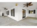Large covered porch featuring multiple windows and ceiling fans at 520 Givhans Rd, Ridgeville, SC 29472