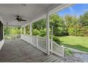 A covered porch with painted railing and a view of the lawn at 520 Givhans Rd, Ridgeville, SC 29472