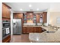 Well-equipped kitchen with stainless steel appliances, granite countertops, dark wood cabinetry, and dark wood floors at 521 Sanders Farm Ln, Wando, SC 29492