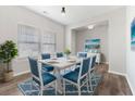 Airy dining room features a dining table and blue chairs set on a patterned rug, and a large window at 525 Purple Finch Rd, Summerville, SC 29486