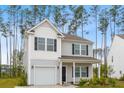 Inviting two-story home boasts a covered porch, a neat front yard, and a single car attached garage at 525 Purple Finch Rd, Summerville, SC 29486