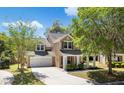 Beautiful two-story home featuring a covered front porch, attached garage, and a serene setting with mature trees at 5471 Rising Tide, North Charleston, SC 29420