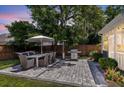 Well-maintained backyard featuring a stone patio, outdoor seating, dining area, grill, and privacy fence at 9670 Pebble Creek Blvd, Summerville, SC 29485