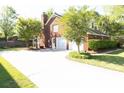 Two-car garage and spacious driveway behind well maintained brick home with lush landscaping at 100 N Gateshead Xing, Goose Creek, SC 29445