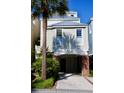 Inviting multi-story beach home featuring a brick-columned facade and breezy, light-filled windows at 103 Grand Pavilion Blvd, Isle of Palms, SC 29451