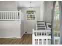 Bright entryway featuring white railings, hardwood floors, and a clear view of the staircase at 105 Brailsford Rd, Summerville, SC 29485