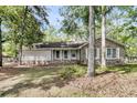 A brick home with a tidy lawn and mature trees providing ample shade, creating a serene outdoor setting at 106 Spring Farm Pl, Summerville, SC 29485