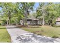 Cozy home features a brick exterior and lush, shady landscaping, nestled amongst mature trees at 106 Spring Farm Pl, Summerville, SC 29485