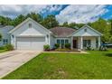 Charming single-story home featuring a well-manicured lawn and a two-car garage at 107 Towering Pine Dr, Ladson, SC 29456