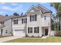 Charming two-story home with a manicured lawn, attached garage and inviting front porch with dark door at 1167 Mossy Rock Dr, Summerville, SC 29485