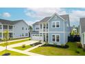 Beautiful two-story blue home featuring a front porch, garage, and landscaped front yard at 127 Archdale St, Summerville, SC 29486