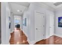 Bright hallway with hardwood floors, white trim, and artwork, leading to a living area with scenic views at 136 Cooper River Dr, Mount Pleasant, SC 29464