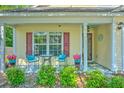 Close up of covered porch with outdoor seating and colorful planters, adding charm to the home's entrance at 138 Avalon Rd, Summerville, SC 29483