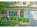 Inviting home exterior showcasing a cozy front porch with seating, lush landscaping, and a well-maintained lawn at 138 Avalon Rd, Summerville, SC 29483