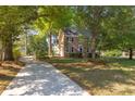 Beautiful two-story brick home with a long driveway and lush lawn, framed by mature trees at 1415 Inland Creek Way, Mount Pleasant, SC 29464