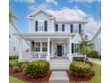 Inviting two-story home with a welcoming front porch, complemented by well-maintained landscaping at 1488 Croaton Crsg, Mount Pleasant, SC 29466