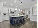 Stylish kitchen with white cabinets, a blue island with seating, and modern pendant lighting at 1488 Croaton Crsg, Mount Pleasant, SC 29466
