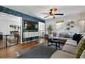 Stylish living room featuring accent wallpaper, hardwood floors, modern furniture, and a ceiling fan at 1514 Gardenia Rd, Charleston, SC 29407