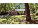 Quaint brick home with lush lawn, shaded by mature trees, offering a serene setting at 1521 Camp Rd, Charleston, SC 29412