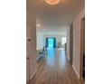 Inviting hallway showcasing modern wood flooring, with views of the kitchen and living areas bathed in natural light at 167 Cypress Plantation Rd, Moncks Corner, SC 29461