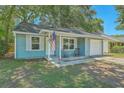Light blue home featuring a charming entrance, one car garage, and well-kept lawn at 184 Tabby Creek Cir, Summerville, SC 29486