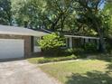 Traditional brick home featuring a two-car garage and well-manicured lawn and lots of shade trees at 1866 Ashley Hall Rd, Charleston, SC 29407
