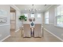 Bright dining room with modern chandelier, multiple windows and view of white kitchen cabinets at 2131 Pentland Dr, Charleston, SC 29412