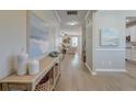 Elegant hallway with light hardwood floors, decorative vases, and artwork leading to living areas at 2131 Pentland Dr, Charleston, SC 29412