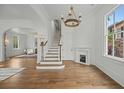 Bright foyer featuring hardwood floors, elegant staircase, fireplace, and arched doorways, exuding sophistication and charm at 24 Chalmers St, Charleston, SC 29401