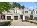 Exterior of townhomes with garages, landscaping, and walkways leading to front door at 2505 Stadium Dr, North Charleston, SC 29406