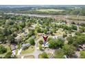 Aerial view of a home and neighborhood surrounded by lush greenery, with waterfront in the distance at 2506 Birkenhead Dr, Charleston, SC 29414