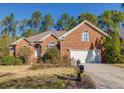 Charming brick home featuring a well-manicured lawn, mature landscaping, and an attached two-car garage at 2800 Waterpointe Cir, Mount Pleasant, SC 29466