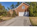 Exterior view of attached two-car garage, showcasing the concrete driveway and mature landscaping at 2800 Waterpointe Cir, Mount Pleasant, SC 29466