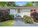 Close up of home's front entrance with attractive landscaping and a cheerful light blue door at 2988 Bolton Rd, Charleston, SC 29414