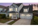 Two-story home featuring a welcoming front porch and a two-car garage at dusk at 361 Ripple Park Dr, Summerville, SC 29486