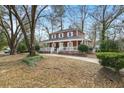 Traditional two-story home with a spacious wrap-around porch surrounded by mature trees and a well-maintained lawn at 49 Crosscreek Dr, Charleston, SC 29412