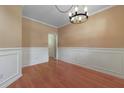 Dining room with a decorative chandelier, wood floors, and wainscoting details at 5418 Percival Ln, Charleston, SC 29420