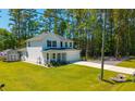 An attractive two-story home with a manicured lawn and a storage shed, surrounded by lush trees at 689 W Butternut Rd, Summerville, SC 29483