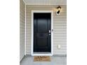 Close-up of a stylish black front door featuring a modern keypad and a welcoming doormat at 703 Hilchot Dr, Summerville, SC 29486