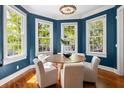 Charming dining room with blue walls, hardwood floors, chandelier, and four windows at 76 Radcliffe St, Charleston, SC 29403