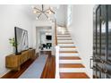 Bright foyer features hardwood floors, staircase, modern light fixture, and decor at 76 Radcliffe St, Charleston, SC 29403